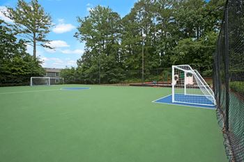 A tennis court with a green surface and a blue surface for practicing serves.
